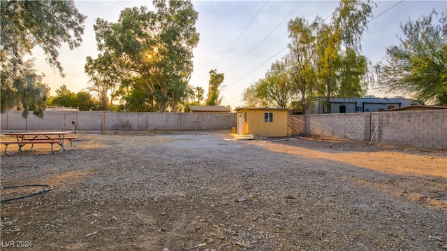 yard at dusk featuring an outbuilding