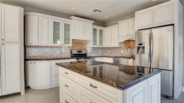 kitchen with white cabinetry, decorative backsplash, appliances with stainless steel finishes, and light tile patterned floors