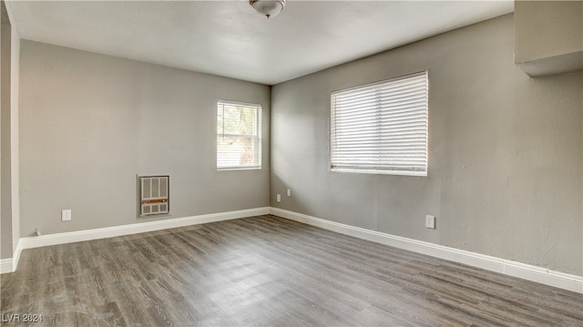 unfurnished room featuring hardwood / wood-style flooring and heating unit