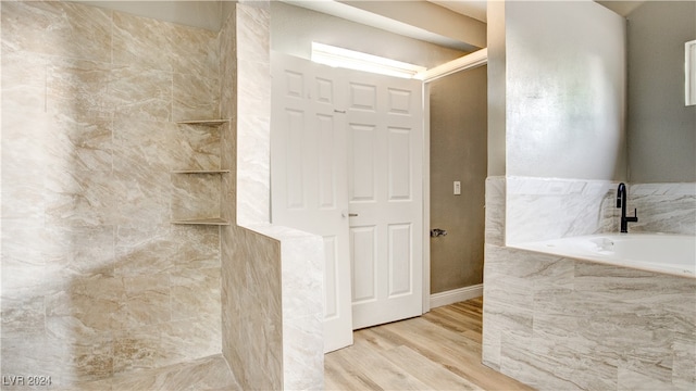 bathroom featuring wood-type flooring and tiled tub