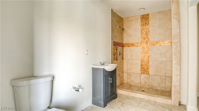 bathroom with vanity, toilet, and a tile shower