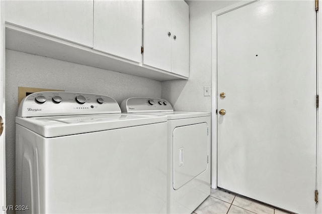 washroom featuring cabinets, light tile patterned floors, and washing machine and dryer