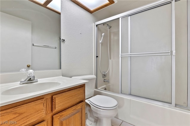 full bathroom featuring vanity, combined bath / shower with glass door, toilet, and tile patterned floors