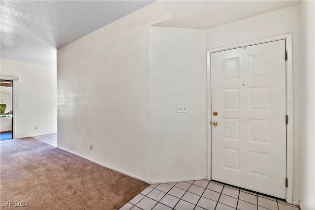 carpeted entrance foyer featuring a textured ceiling