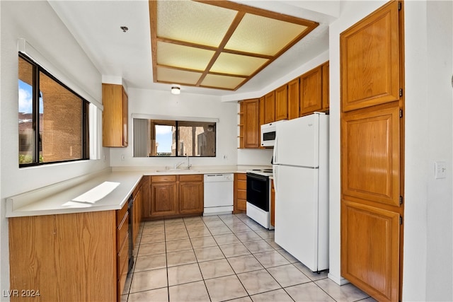 kitchen featuring white appliances, light tile patterned floors, and sink