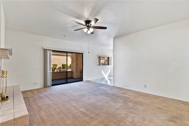 unfurnished living room featuring light carpet, ceiling fan, and a textured ceiling