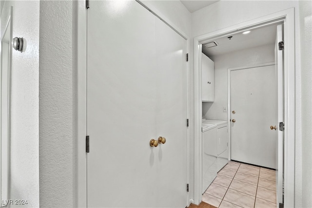 washroom featuring washer and clothes dryer, light tile patterned flooring, and cabinets