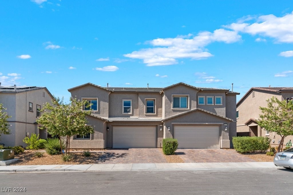 7013 Fossil Rim St Unit 0, North Las Vegas, NV 89084 - view of front of home with decorative driveway, an attached garage, and stucco siding