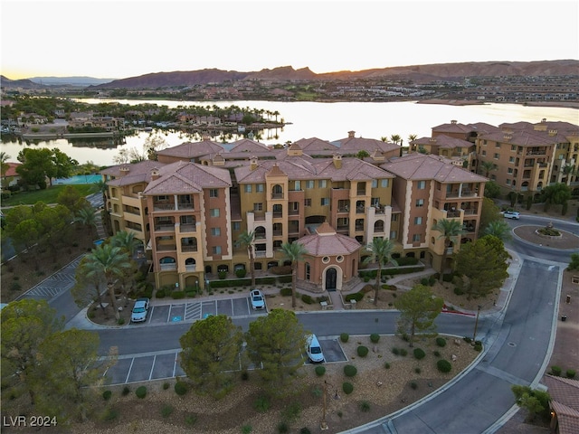 aerial view at dusk featuring a water view