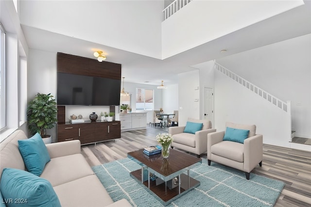 living room with a towering ceiling and light wood-type flooring