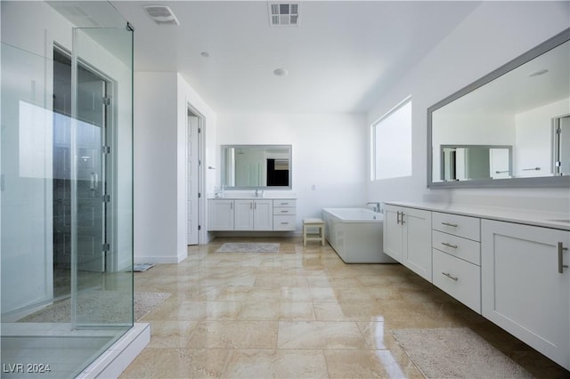 510 Duvet Ct, Henderson, NV 89012 - bathroom featuring a garden tub, a sink, a stall shower, two vanities, and visible vents