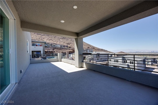 view of patio with a balcony and a mountain view