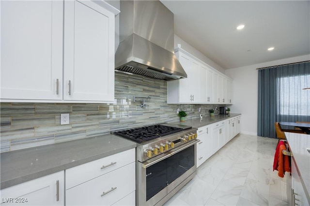 kitchen with tasteful backsplash, island exhaust hood, range with two ovens, and white cabinetry