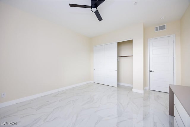 unfurnished bedroom featuring ceiling fan and a closet