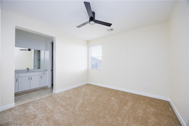 interior space featuring ceiling fan, light colored carpet, and sink