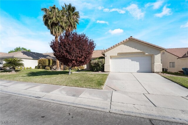 view of front of home with a front yard and a garage