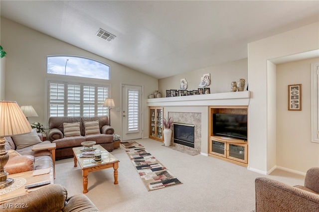 living room with carpet, a tiled fireplace, and vaulted ceiling