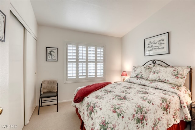 carpeted bedroom featuring a closet and vaulted ceiling