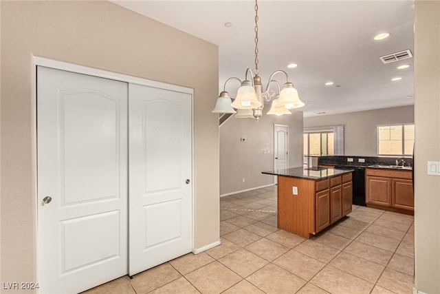 kitchen featuring a chandelier, pendant lighting, a center island, and light tile patterned flooring