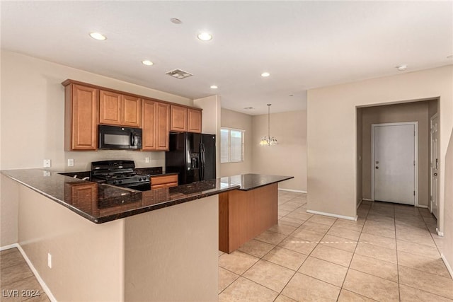 kitchen featuring kitchen peninsula, dark stone counters, black appliances, a chandelier, and hanging light fixtures