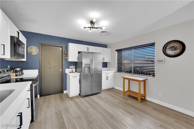 kitchen with a notable chandelier, stainless steel appliances, light hardwood / wood-style floors, and white cabinets