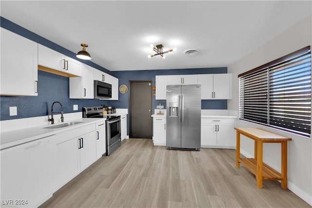 kitchen with stainless steel appliances, sink, white cabinets, and light wood-type flooring