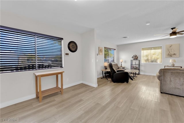 living room featuring ceiling fan, light hardwood / wood-style flooring, and a healthy amount of sunlight