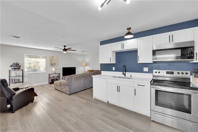 kitchen featuring stainless steel appliances, sink, white cabinets, and light wood-type flooring