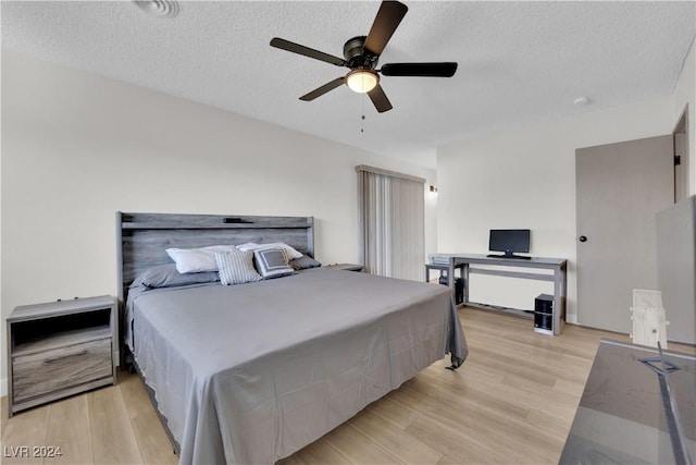 bedroom featuring a textured ceiling, light hardwood / wood-style flooring, and ceiling fan