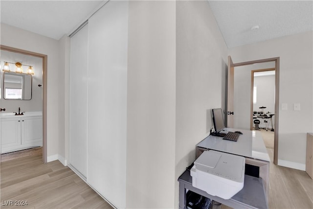 corridor featuring light hardwood / wood-style floors and a textured ceiling