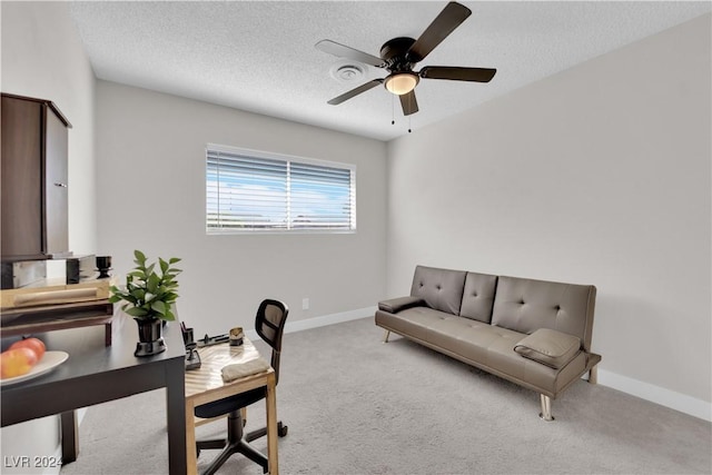 carpeted office space with ceiling fan and a textured ceiling