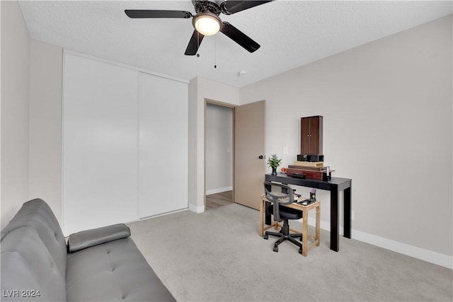 office area with ceiling fan, light colored carpet, and a textured ceiling