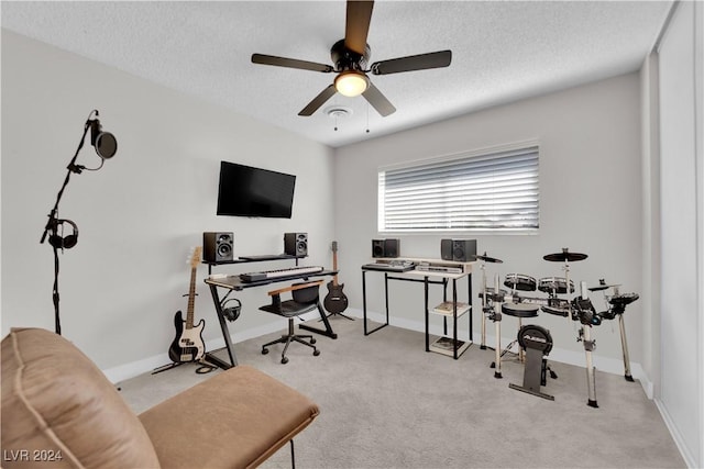 carpeted office featuring ceiling fan and a textured ceiling