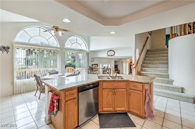 kitchen with stainless steel dishwasher, sink, ceiling fan, and an island with sink