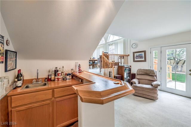 kitchen featuring kitchen peninsula, sink, and light colored carpet