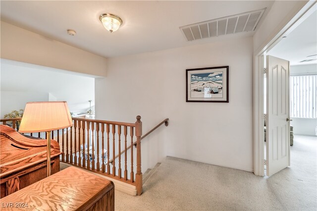 hallway featuring light colored carpet