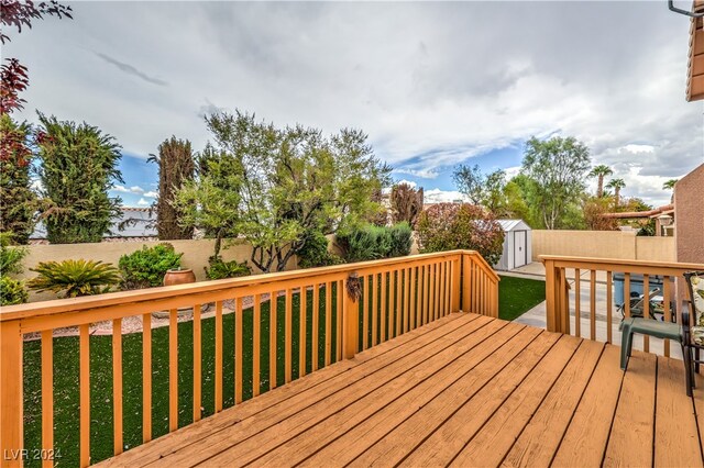 deck with a storage shed and a yard