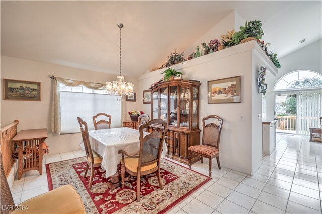 tiled dining space featuring a notable chandelier and high vaulted ceiling