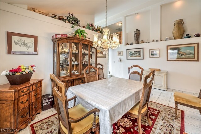 tiled dining space featuring an inviting chandelier and vaulted ceiling