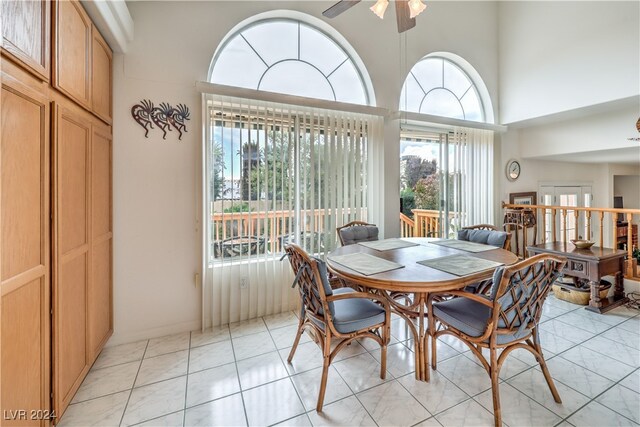 tiled dining room with a towering ceiling and ceiling fan