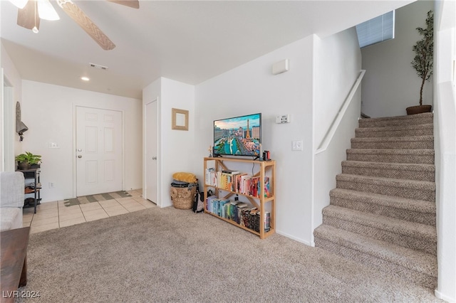 foyer with ceiling fan and light colored carpet