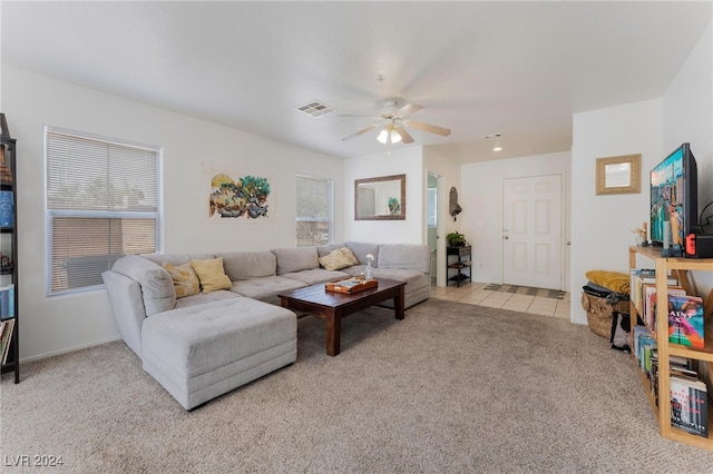 living room with a wealth of natural light, ceiling fan, and light colored carpet