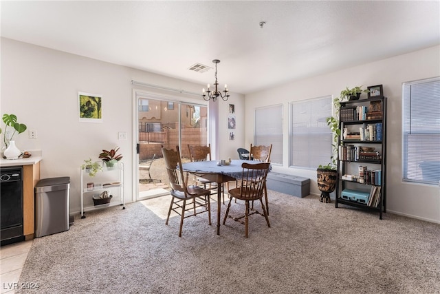 dining area featuring light carpet and a chandelier