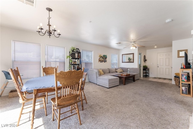 dining room featuring light colored carpet, ceiling fan with notable chandelier, and plenty of natural light