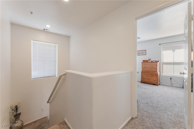 corridor featuring light colored carpet