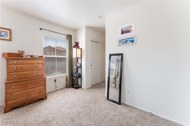 bedroom featuring light carpet and a closet