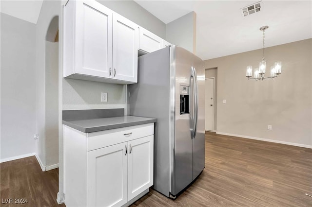 kitchen with stainless steel fridge, white cabinetry, and dark wood-type flooring