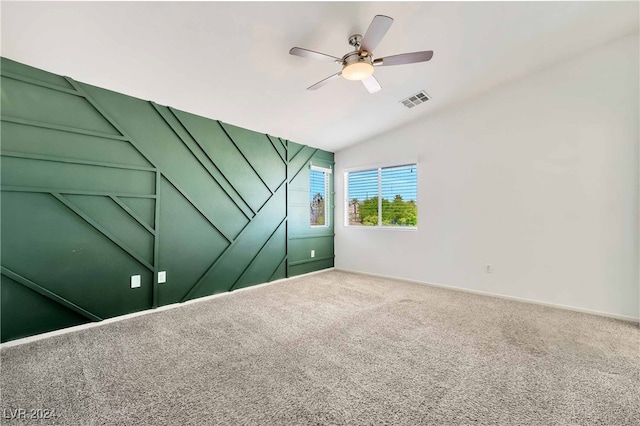 carpeted spare room featuring ceiling fan and vaulted ceiling