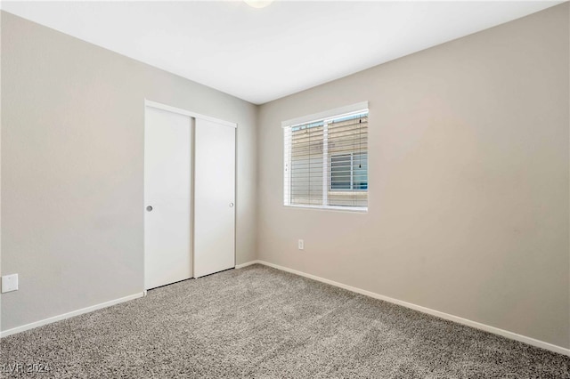 unfurnished bedroom featuring carpet floors and a closet