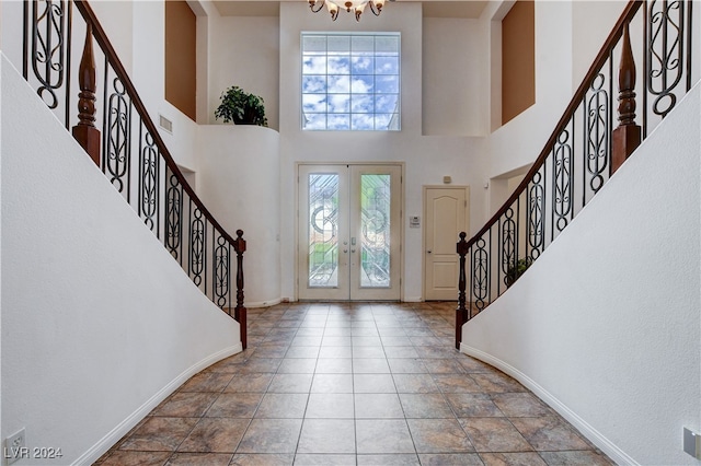 entryway featuring a towering ceiling and french doors